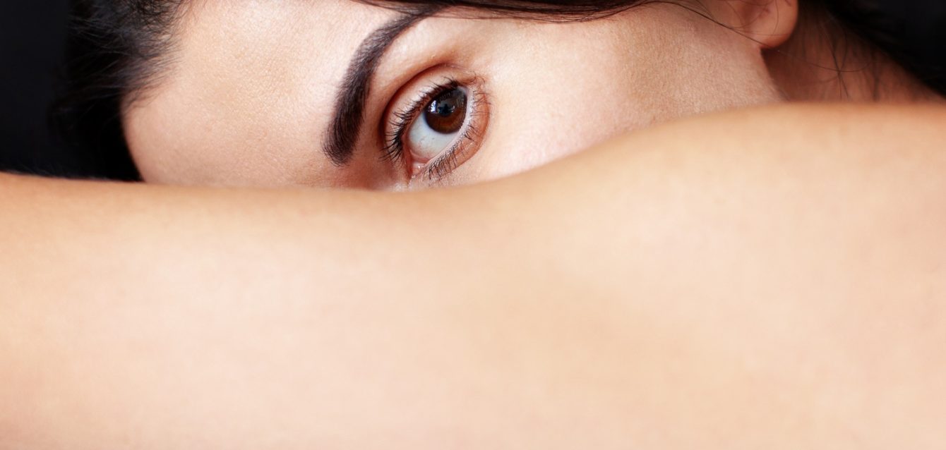 Surreal woman portrait. Abstract fashion surrealistic face, close up eye on black background